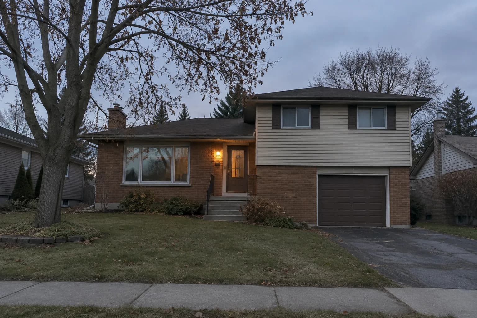 Illustrative Ontario split-level brick house at dusk.