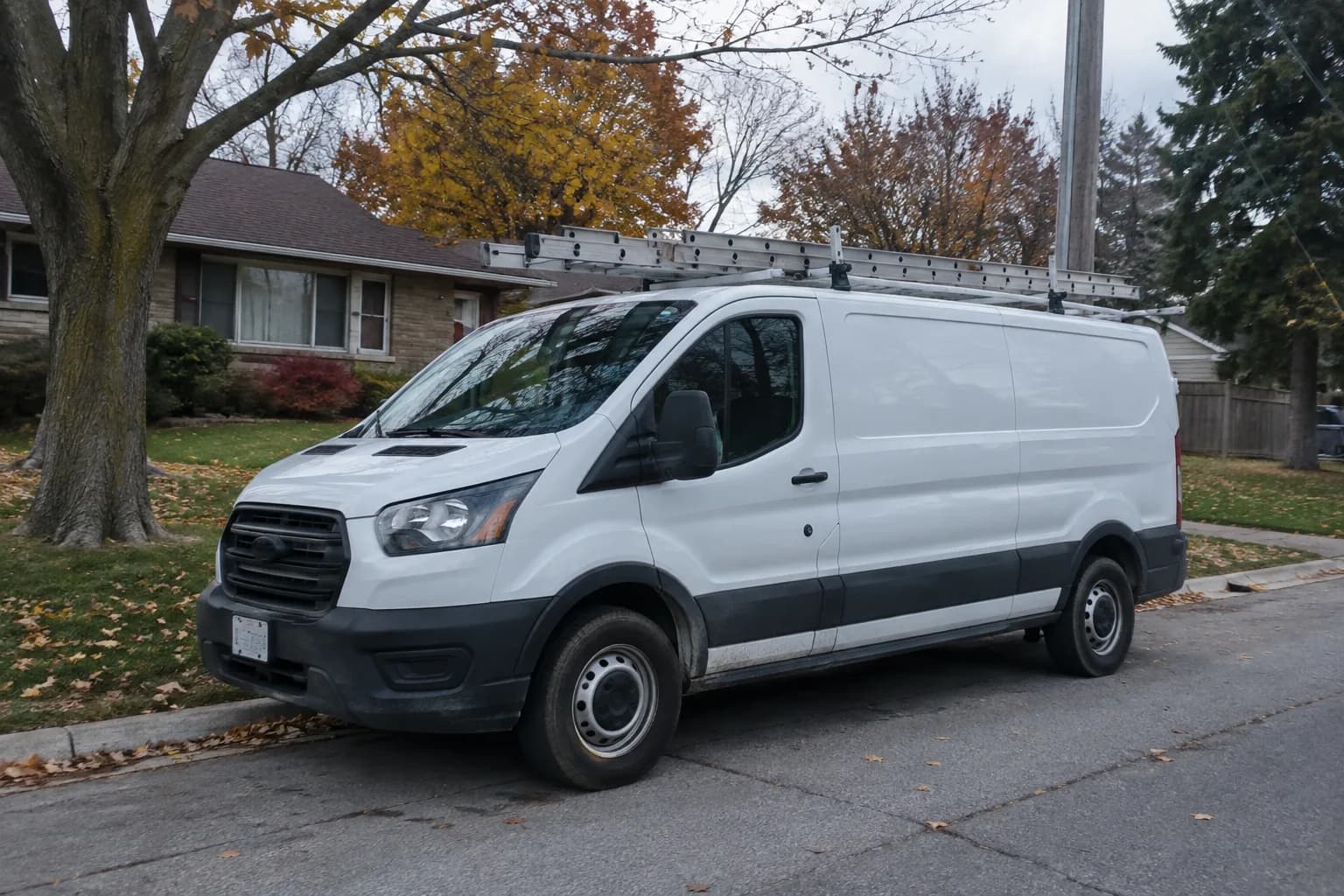 Illustrative white service van on a tree-lined residential street.